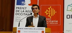 Bertrand Monthubert à la tribune du lancement du CTD Occitanie, devant les kakémonos Etat, Région Occitanie et OPenIG